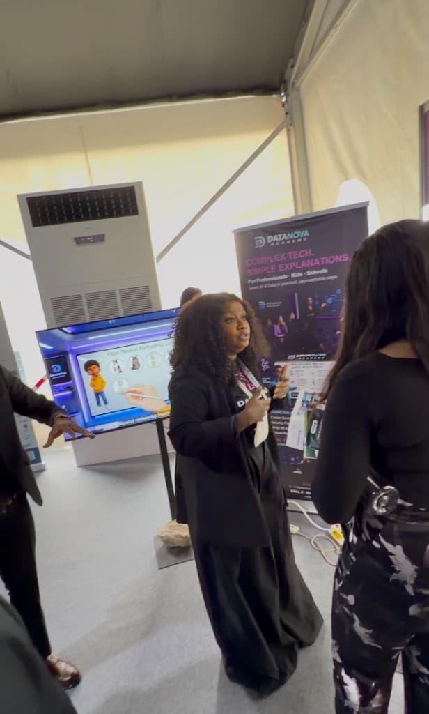 A DataNova colleague explaining neural networks on the Academy screen.