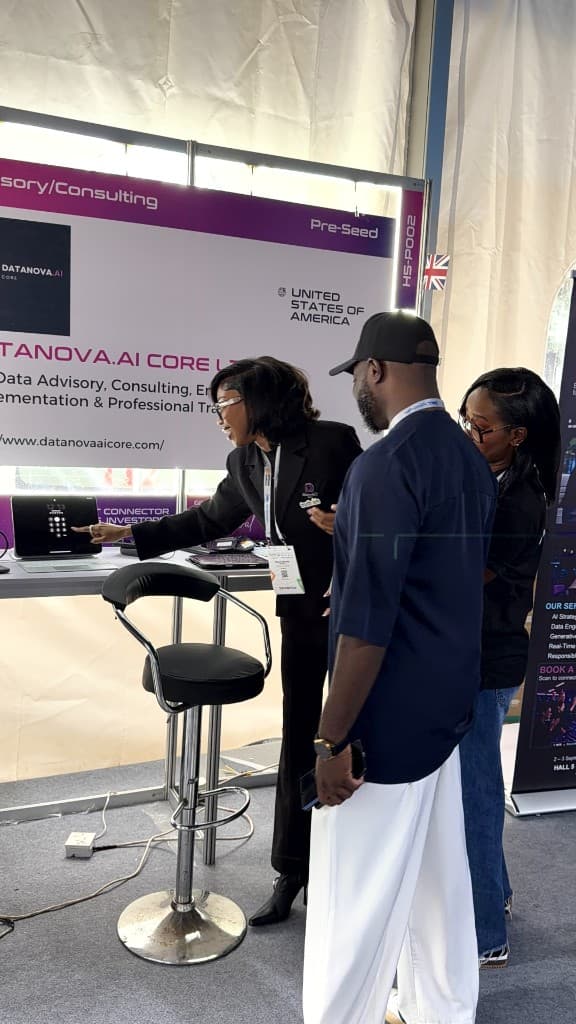 A DataNova colleague walking visitors through a laptop demo.